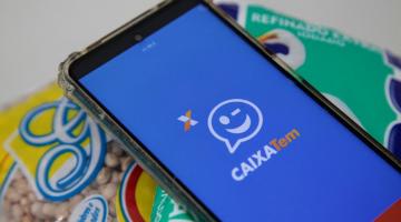 celular com aplicativo do caixa tem sobre alimentos de cesta #paratodosverem