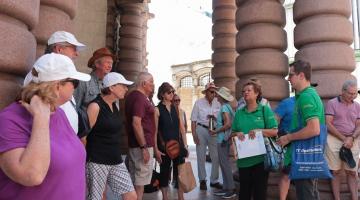 turistas estão parados junto a guias na entrada do museu do café. #paratodosverem 