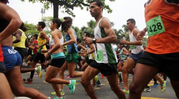 Pessoas estão correndo em avenida. #Pracegover