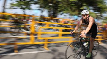 ciclista em prova de triátlon em avenida #paratodosverem