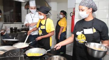 alunos cozinham supervisionados por professor #paratodosverem 