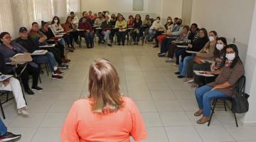 pessoa falando para diversas pessoas sentadas em forma circular. #paratodosverem