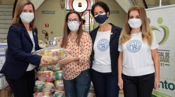 mulheres posam com alimentos doados #paratodosverem 