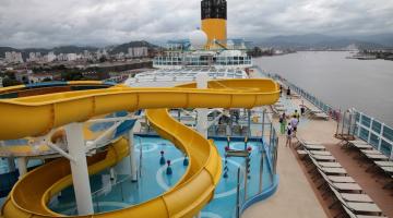 vista geral do navio com tobogã para piscina em primeiro plano. #paratodosverem