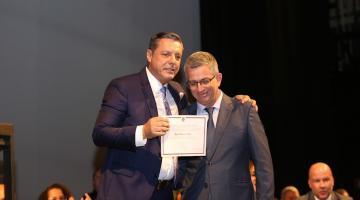 o prefeito segura o diploma e abraça o juiz eleitoral. #paratodosverem