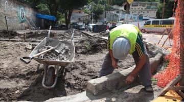 homem está construindo guia de calçada. #paratodosverem