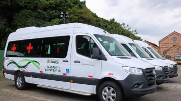 três vans enfileiradas , com logotipo da prefeitura de santos #paratodosverem