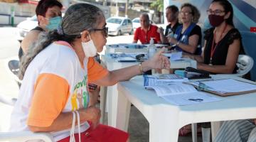 mulher está sentada sendo atendida por pessoas do procon. #paratodosverem