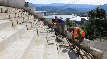 homens finalizam construção de escadaria no alto de um morro. #paratodosverem