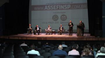 auditório com pessoas sentadas assistindo apresentação de pessoas no palco. #paratodosverem