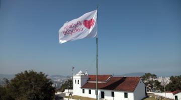 bandeira tremulando no alto do morro com igreja abaixo #paratodosverem