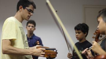 professor instrui alunos sobre instrumentos #paratodosverem