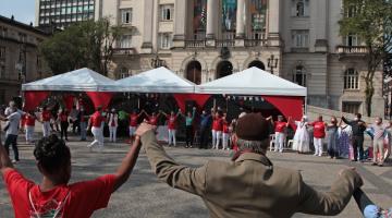 pessoas de mãos dadas e para cima em circulo na praça #paratodosverem