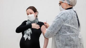 Mulher grávida recebe a vacina de enfemeira. #paratodosverem