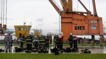 alunos com uniformes de combate ao fogo se preparam para entrar no flutuante. #paratodosverem 