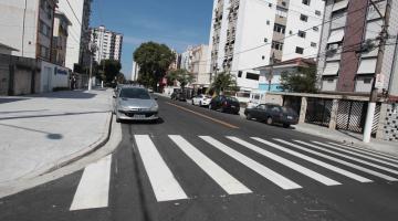 Rua recém-pavimentada, com faixa de segurança pintada. #Pracegover