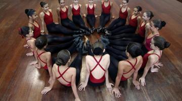 bailarinas sentadas em circulo no palco #paratodosverem