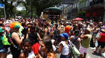 Festa do carnabonde, com praça lotada de gente e o bonde ao fundo. #paratodosverem 