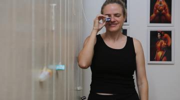 mulher segura e olha dentro de monóculo. #paratodosverem 