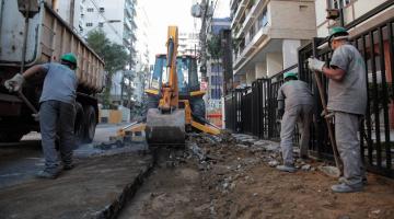 trator na rua removendo paralelepípedos e homens trabalhando, #paratodosverem