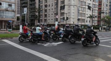 motociclistas parados em faixa para motos diante de semáforo. #paratodosverem