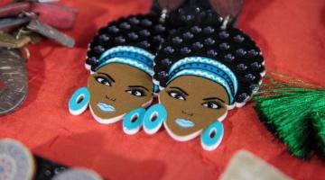 brincos com imagens do rosto de mulher negra, com adereço nos cabelos e brincos. #paratodosverem 