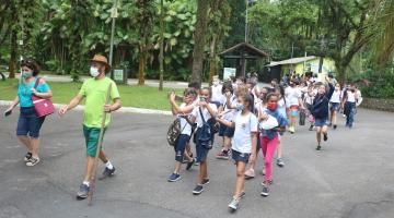 Crianças com instrutor andam em fila no parque #paratodosverem