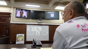 homem está de costas para a foto e de frente para telões. #paratodosverem