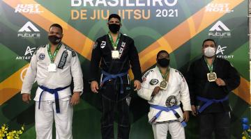 Atletas com quimono no pódio com medalhas #paratodosverem