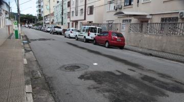 Rua com carros parados do lado direito. #Paratodosverem