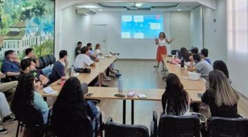 jovens reunidos em sala sentados em mesa #paratodosverem 