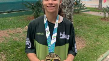 atleta posa para foto segurando medalha de ouro #paratodosverem