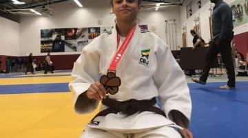 judoca de joelhos com a medalha ao peito #paratodosverem