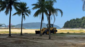 máquina atuando na praia #paratodosverem 