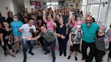 grupo de idosas posa para foto com Vava e Marcio à frente. #paratodosverem