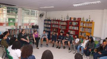 alunos em círculo com jornalista #paratodosverem 