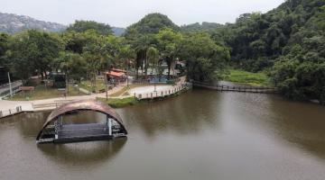 vista aérea da lagoa da saudade, com palco flutuante na água, vegetação e área de lazer ao fundo. #paratodosverem