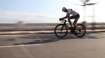 lauro chama está pedalando na ponta da praia. A velocidade da bike distorce, na imagem, as muretas ao fundo. #partodosverem