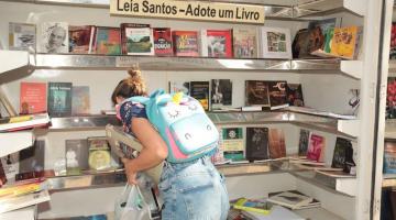 mulher retira livro de display #paratodosverem 