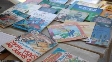 vários livros expostos sobre uma mesa. #paratodosverem