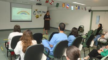 pessoa fala em sala de aula com pessoas sentadas #paratodosverem