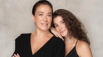 Lilia Cabral e a filha Giulia posam juntas para foto. A filha está atrás da mãe com as mãos no ombro e no braço direito. #paratodosverem