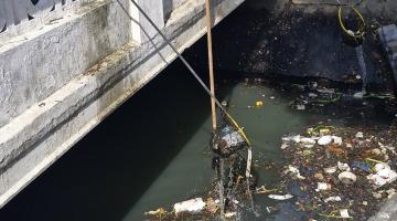 operários limpando canal #paratodosverem 