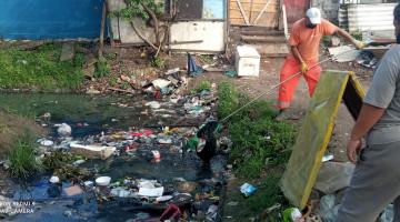 Trabalhador retira lixo de dentro de vala #paratodosverem
