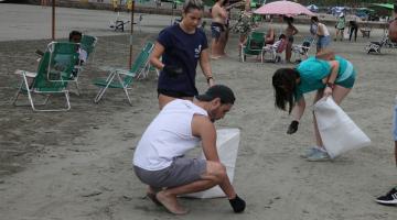 pessoas limpando resíduos da praia #paratodosverem 