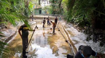 homens estão dentro de lago com pouca água. #paratodosverem