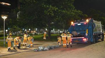 funcionários recolhem lixo na faixa de areia e jardim. #paratodosverem