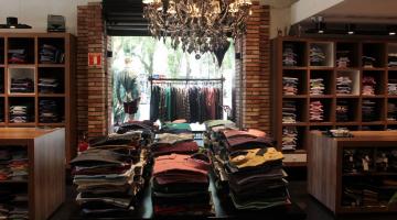 Interior de loja de roupas com vista para a vitrine. #Paratodosverem