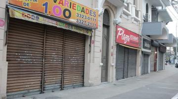 Várias lojas de rua com portas fechadas. Rua está vazia. #Paratodosverem