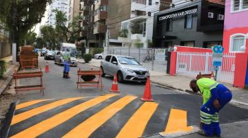 Operário faz pintura de lombada ao lado esquerdo da via. #paratodosverem